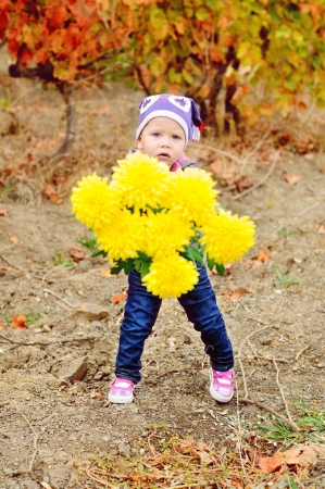 baby with flowers for mother walking outdoorsの写真素材
