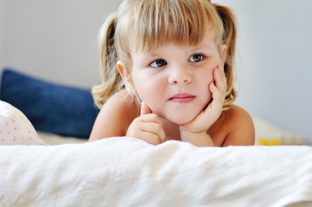 toddler girl laying in bedの写真素材