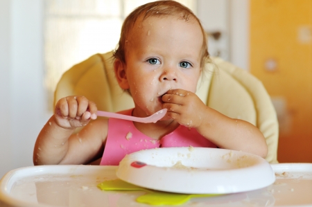 eating baby girl with dirty faceの写真素材