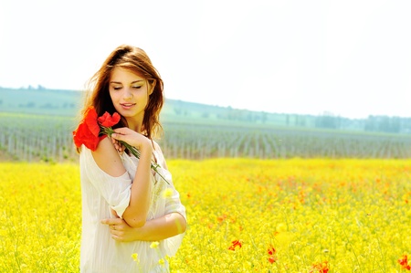 happy beautiful girl in rapeseed field in bloomの写真素材