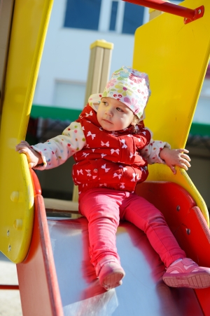 toddler girl  on slide on the playgroundの写真素材