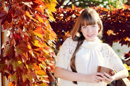 girl with mug of hot drink in sunny dayの写真素材