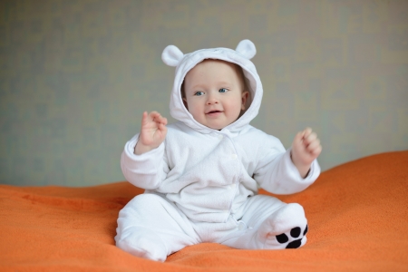 claping baby in motion sitting on the sofaの写真素材