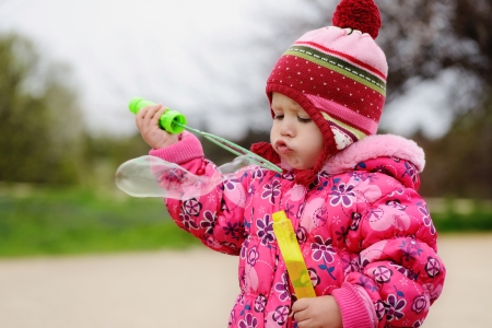 little toddler girl blowing huge bubbleの写真素材