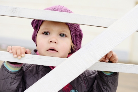 country baby girl looking through fenceの写真素材
