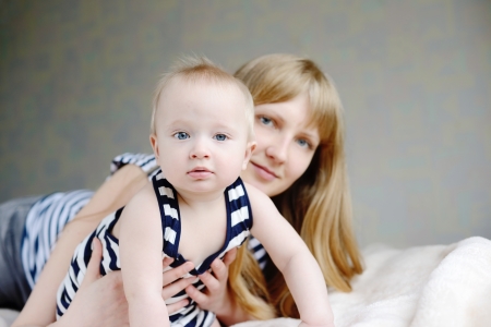 mother and her baby son laying on the sofaの写真素材