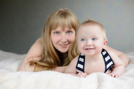 mother and her baby laying on the sofa の写真素材