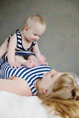 mother holding baby, thay are wearing striped topsの写真素材