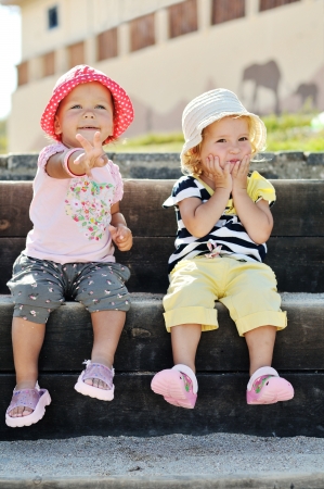 two happy toddler girls having fun outdoorsの写真素材