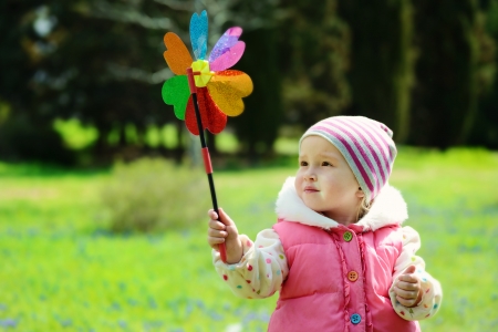 toddler girl with windmill in spring dayの写真素材
