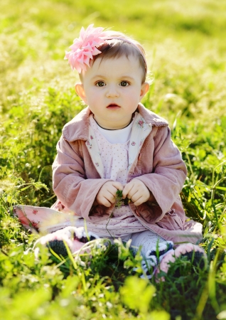 fashion baby  girl sitting in grassの写真素材