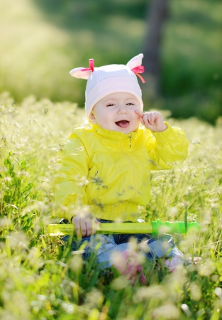 laughing baby sitting in green grassの写真素材