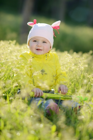 happy baby sitting on the sunny meadowの写真素材