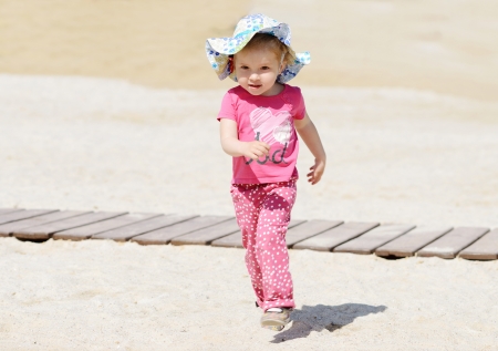 toddler girl running on the beachの写真素材