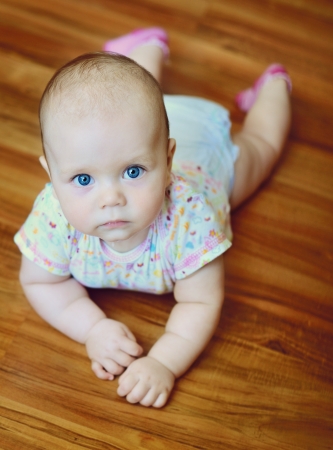 baby laying on the wooden floorの写真素材