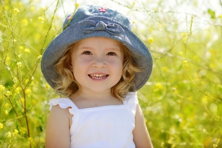happy toddler girl  in rape fieldの写真素材