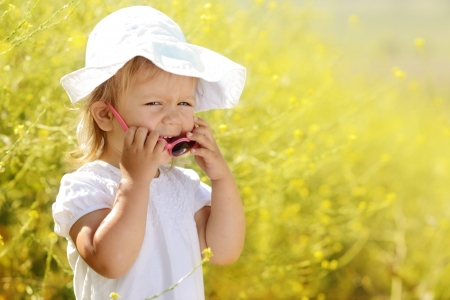 laughing toddler girl  in rape fieldの写真素材