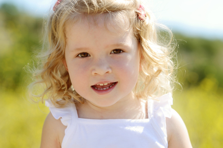 happy toddler girl in rape seed fieldの写真素材