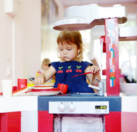  toddler girl playing toy kitchenの写真素材