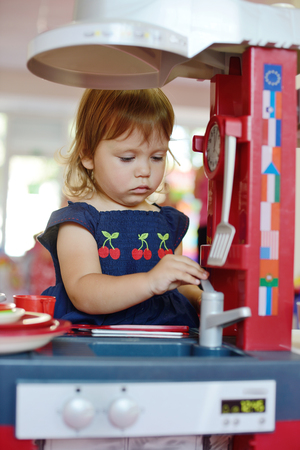  toddler girl playing toy kitchenの写真素材