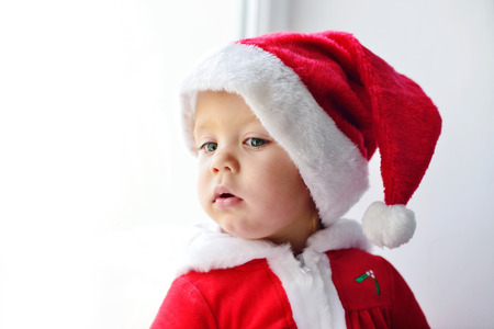baby santa looking in the  windowの写真素材