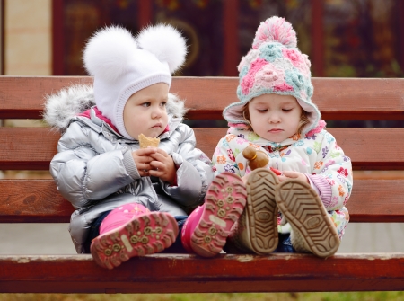 baby friends sitting on the benchの写真素材