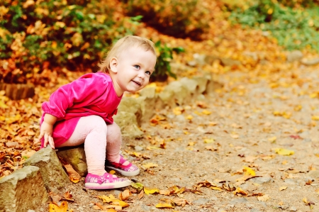 toddler girl having fun  in fall parkの写真素材