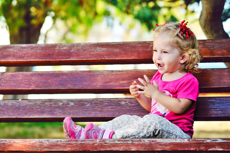 Ñute toddler girl sitting on the benchの写真素材