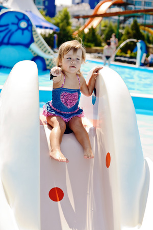 cute toddler on the water slide in aqua parkの写真素材