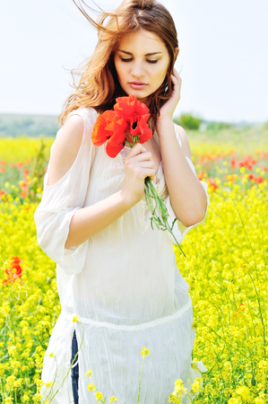 happy beautiful girl in rapeseed field in bloomの写真素材