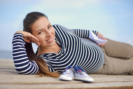 beautiful longhaired pregnant woman on the sea coastの写真素材