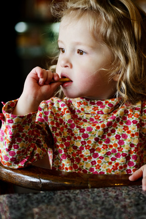 thoughtful toddler girl in cafeの写真素材