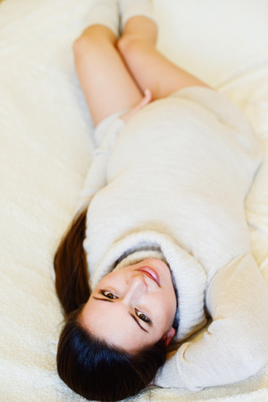 pretty pregnant woman laying on the sofaの写真素材