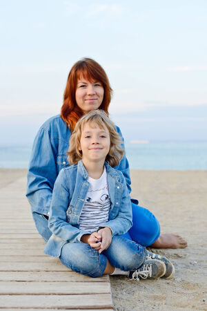 mother and daughter resting near the seaの写真素材