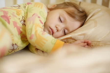 sleeping toddler girl wearing pajamaの写真素材