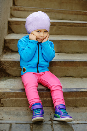 cute toddler sitting on the stairsの写真素材