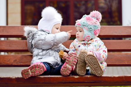 baby friends sitting on the benchの写真素材