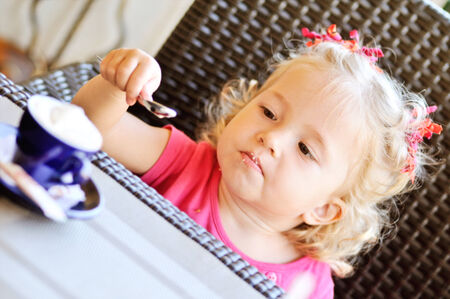 funny toddler girl in cafeの写真素材