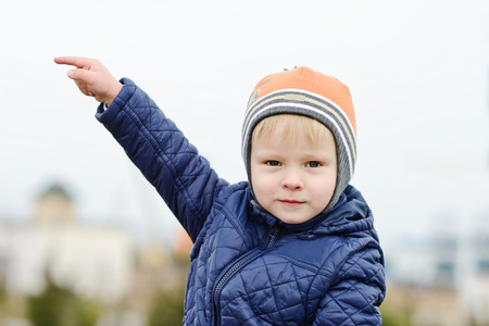 toddler boy is pointing on the left  outdoorsの写真素材