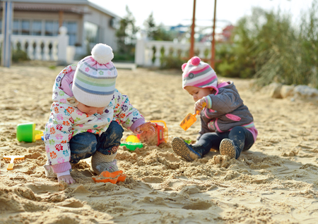 two baby girls playing in sandの写真素材