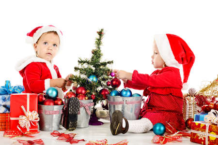 two santa helpers decorating a treeの写真素材