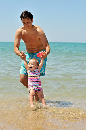 fun of father and baby girl on the beachの写真素材