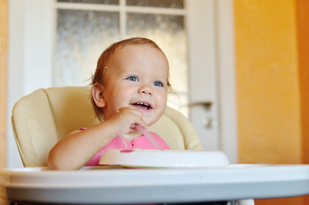 laughing eating baby girl with dirty faceの写真素材