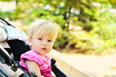 sweet baby girl sitting in strollerの写真素材