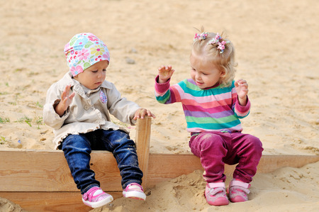 happy toddlers playing in sandの写真素材