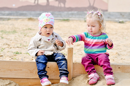 toddler girls playing in sandの写真素材