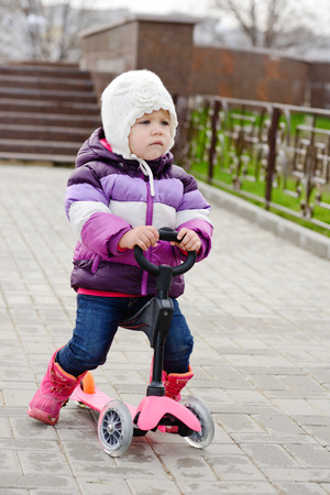 baby girl on scooter in the parkの写真素材