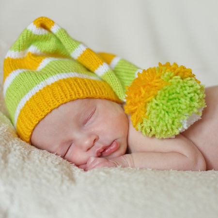 sweet newborn wearing striped long hat の写真素材