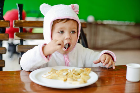 toddler girl eating in outdoor cafeの写真素材