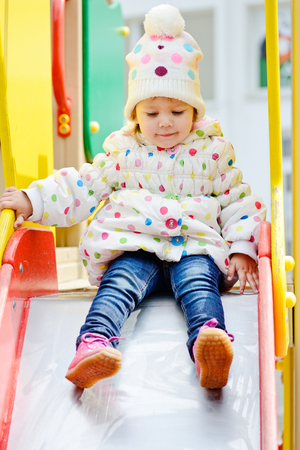 cute toddler on slide on the playgroundの写真素材